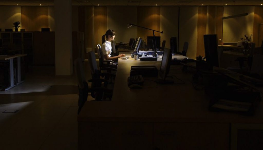 Woman Using Computer In Dark Office