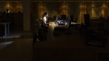 Woman Using Computer In Dark Office