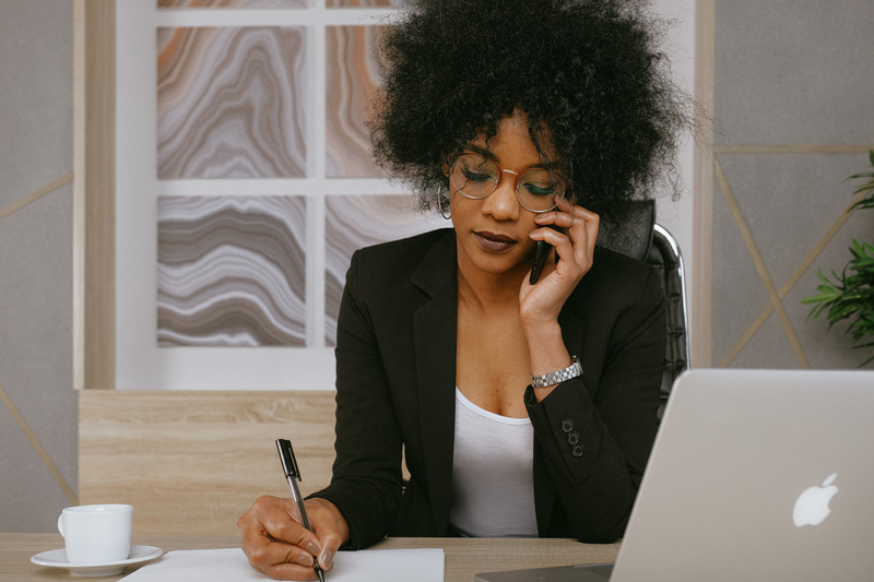 Black Woman In Black Blazer Holding Smartphone