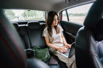 Busy BragWoman Using Laptop Computer Inside Vehicle