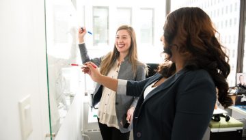 Canva - Two Women in Front of Dry-erase Board
