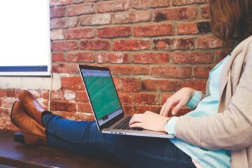 Canva - Woman Sitting on Bench Using Macbook