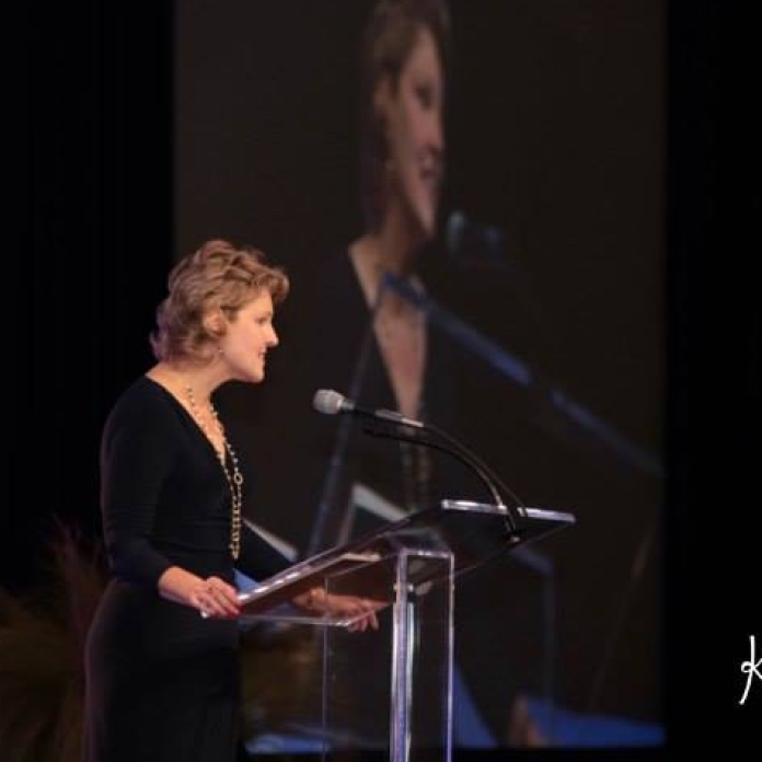 Caroline speaking at podium