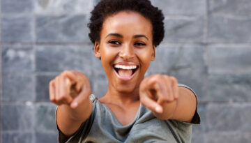 attractive happy young black woman pointing fingers