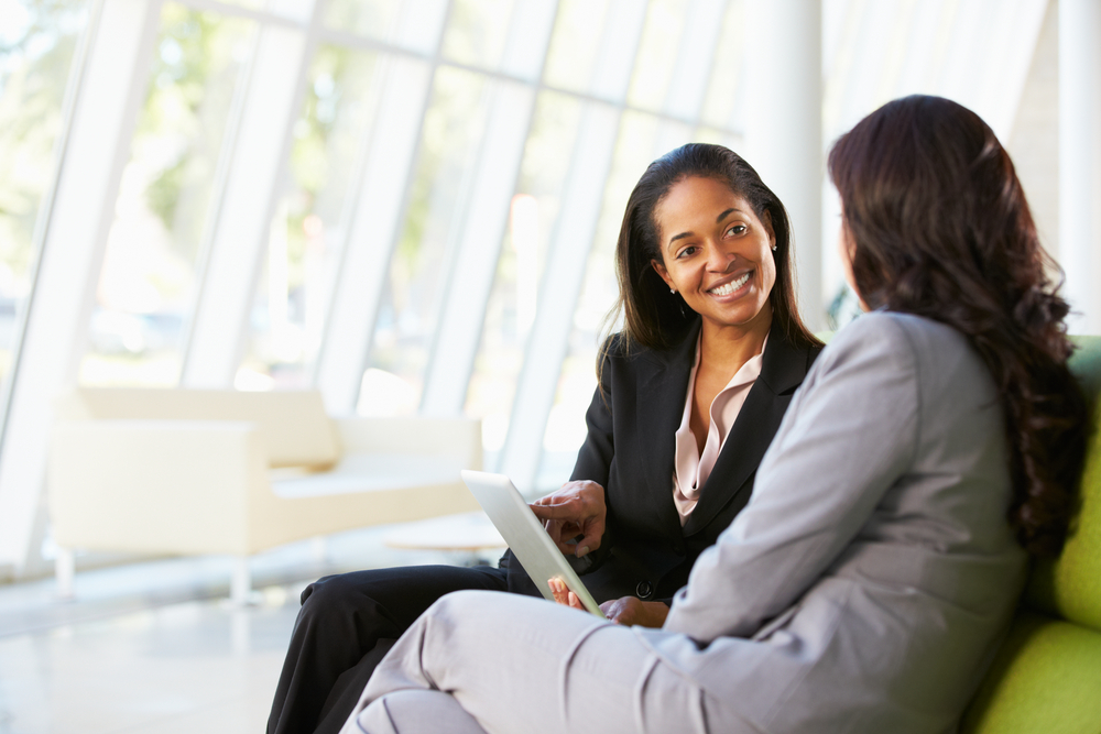 Businesswomen With Digital Tablet Sitting In Modern Office