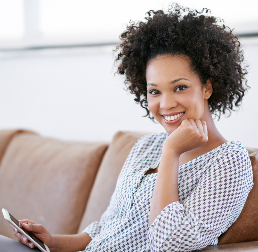 Nowhere more relaxing than home. Portrait of an attractive woman sitting on the sofa with her smartphone. Nowhere more relaxing than home. Portrait of an attractive woman sitting on the sofa with her smartphone.