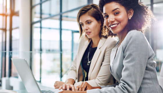 Nothing but productivity when we partner up. two young businesswomen using a laptop together at work.