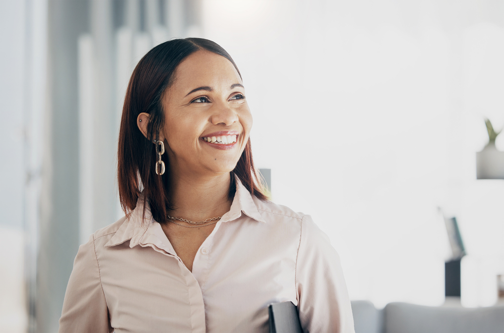 Smile, happy and businesswoman in the office with confident, good and positive attitude. Happiness, ambition and professional female lawyer or attorney from Colombia standing in modern workplace.