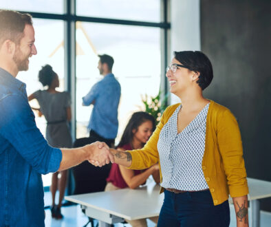 Handshake, woman and man in creative meeting with smile, introduction and collaboration in office together. Workshop, agreement and business people shaking hands at design agency for happy welcome.