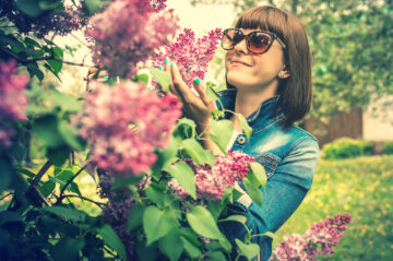 LIlacsCanva - Photo of a woman wearing sunglasses holding lilac flowers