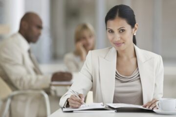 Young business woman making notes while at the canteen