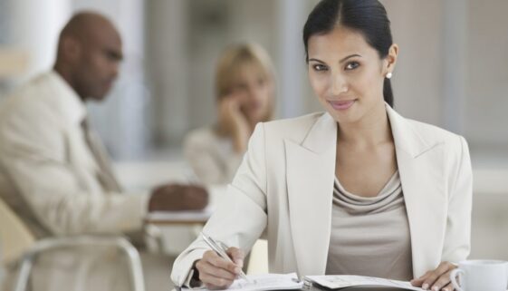 Young business woman making notes while at the canteen