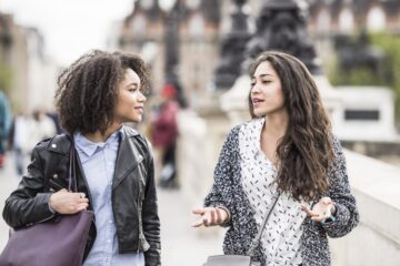 Two female friends talking outdoors in Paris, France