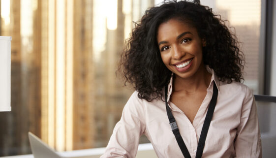 Portrait Of Smiling Businesswoman With Security Pass On Lanyard In Office