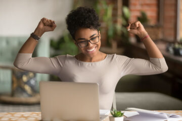 Excited african woman feeling winner rejoicing online win on laptop