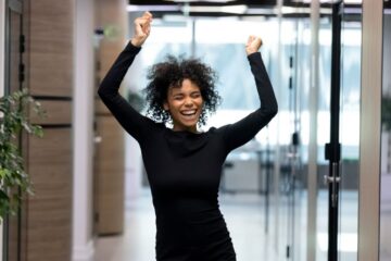Overjoyed African American female employee dance celebrating success