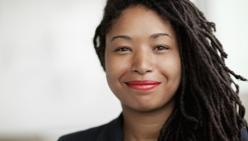 Portrait of smiling businesswoman with dreadlocks, head and shoulders