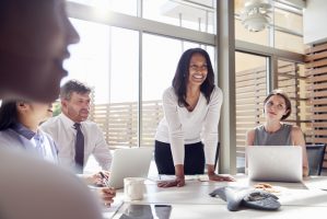Smiling female manager listening to colleagues at a meeting Smiling female manager listening to colleagues at a meeting