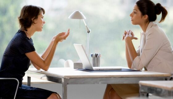 two woman at work across desk profiles